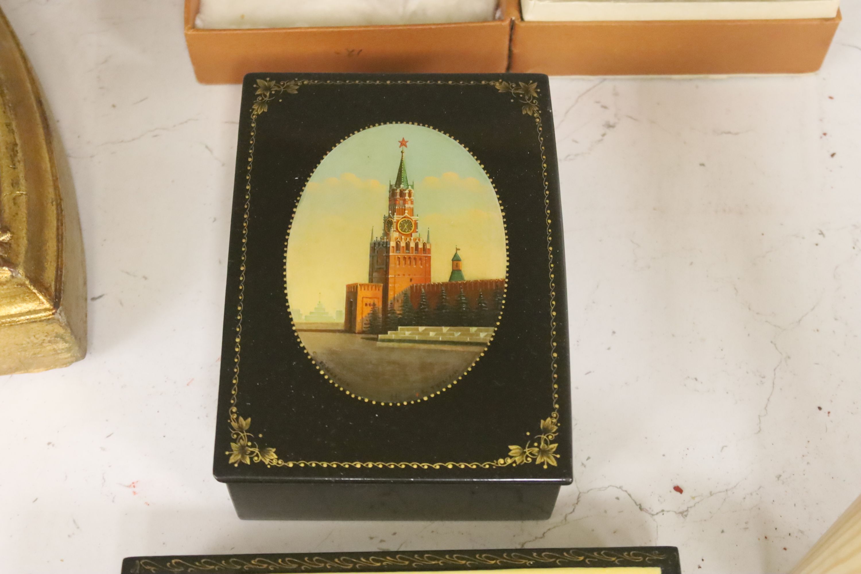 Six Russian Papier mache boxes, each decorated with churches or cathedrals, largest 17 cm